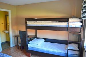 two bunk beds in a room with a desk at Lyckåhem Lågprishotell och Vandrarhem in Karlskrona