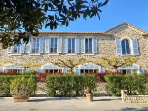 カンヌにあるLa Bastide du Soleilの青い窓と植物が目の前にある建物