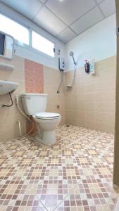 La salle de bains est pourvue de toilettes et de carrelage. dans l'établissement Phuviewplace Hotel - โรงแรมภูวิวเพลส, à Ban Ngun