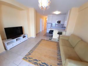 a living room with a couch and a flat screen tv at Playa De Las Vistas in Arona