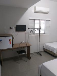 a room with a desk and a tv and a bed at Roda Viva Park Hotel in Jales +17 photos