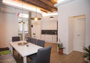 uma sala de jantar e cozinha com uma mesa branca e cadeiras em Mai & Maud Ronda Apartment em Barcelona