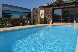 a swimming pool in front of a house at Villa Maravilla piscina climatizada in Villaverde