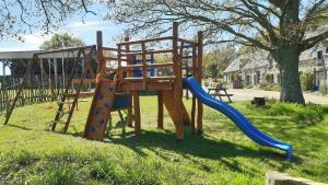 a park with a playground with a slide at La petite grange, La vieille ferme in Ruffiac