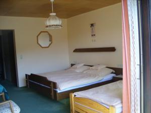 a bedroom with two beds and a mirror at Pension Williams in Seebach