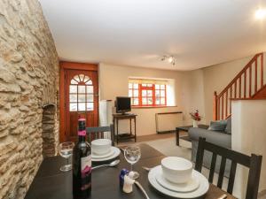 een woonkamer met een tafel met een fles wijn bij Jasmine Cottage in Beaminster