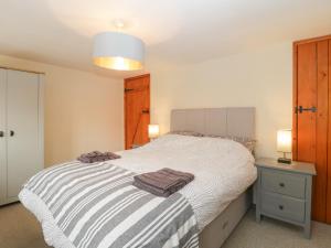 una camera da letto con un letto e due asciugamani di Jasmine Cottage a Beaminster