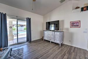 a living room with a tv and a large window at Bright Lake Havasu City Abode with Private Pool in Lake Havasu City