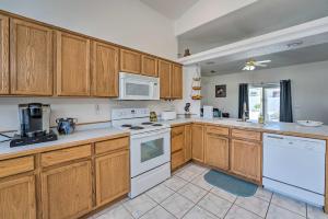 uma cozinha com armários de madeira e electrodomésticos brancos em Bright Lake Havasu City Abode with Private Pool em Lake Havasu City