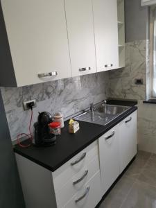 a kitchen with white cabinets and a sink at CAV Black Pearl by People in Turin