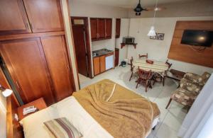 a kitchen and a living room with a bed and a table at Apto ao lado da Rua Torta in Gramado