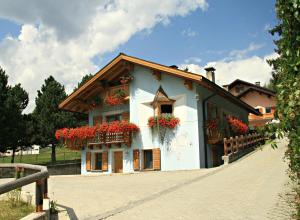 a white building with red flowers on it at Chalet Alfonz in Bormio