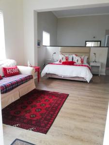 a bedroom with two beds and a red rug at Akwa in Hermanus