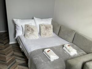a couch with two pillows and two towels on it at Apartment Katowice Center-1 in Katowice