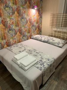 Una cama con sábanas blancas y toallas. en Сomfort24 Апартаменти на проспекті Гагаріна Мечнікова Apartment on Gagarina, en Dnipro