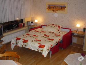 a bedroom with a bed with red flowers on it at Ferienwohnung Kleinschmidt in Heimbach