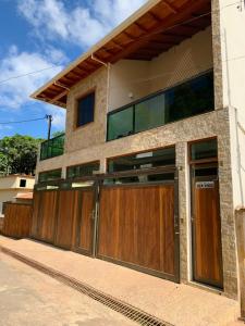 a house with wooden garage doors on a street at Casa Temporada Tiradentes in Tiradentes