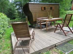 a deck with two chairs and a table and a house at Bienenwagen der Naturheilpraxis Melchger in Wildberg