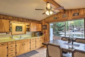 a kitchen with a table and a ceiling fan at Flathead Lake Waterfront Cabin with Dock and Kayaks in Polson
