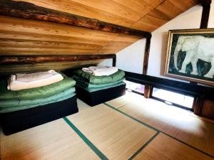 an attic room with two beds and a painting of an elephant at Guesthouse Yadocurly in Onomichi