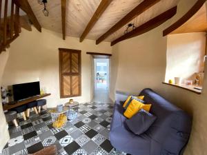 uma sala de estar com um sofá azul e um piso xadrez em LE MOULIN DES GARDES em Saint-Georges-du-Puy-de-la-Garde