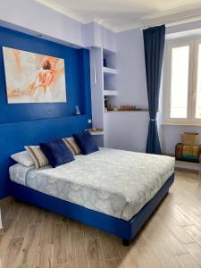 1 dormitorio azul con 1 cama con pared azul en Ambramarina B&B, en Nettuno