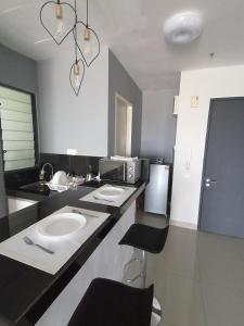 a bathroom with a sink and a counter with chairs at THE FAMILY HOMESTAY@UNIV360 PLACE,SERDANG in Seri Kembangan