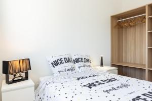 a bedroom with a bed with a black and white comforter at Résidence Le Marly in Annemasse