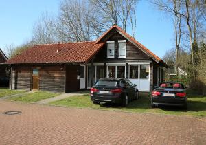 uma casa com dois carros estacionados em frente em Haus Janina em Rieste