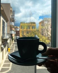 a person holding a coffee cup on a window sill at Ambramarina B&B in Nettuno +27 photos