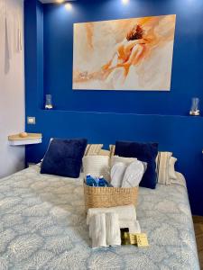 Un dormitorio azul con una cama con una cesta de toallas en Ambramarina B&B, en Nettuno