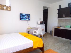 a bedroom with a bed and a table and a kitchen at Pride Studio Mtwapa in Mombasa