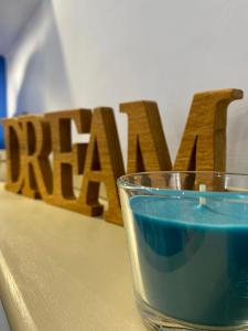 a glass of blue liquid in front of a wooden sign at Ambramarina B&B in Nettuno