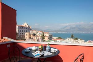 a table on a balcony with a view of the water at Dimora del Leone Gaeta in Gaeta
