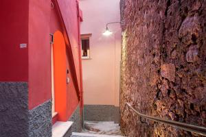 a hallway of a building with a red and orange wall at Dimora del Leone Gaeta in Gaeta