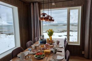 uma sala de jantar com uma mesa e vista para o oceano em Magic views and walking distance to best beaches em Leknes