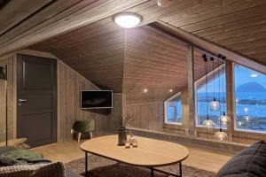ein Wohnzimmer mit einem Tisch und einem großen Fenster in der Unterkunft Magic views and walking distance to best beaches in Leknes