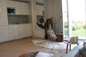 a young girl jumping on a rope in a living room at Cluxury-Torre dei Saraceni BOUTIQUE APT BY THE SEA Beach, Pool,Private Jacuzzi, Parking in Cervo