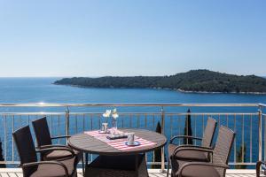 a table and chairs on a balcony with the ocean at Apartments Villa Ari in Dubrovnik