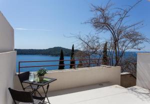 balcón con mesa y vistas al agua en Apartments Villa Ari, en Dubrovnik