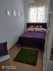 1 dormitorio con cama morada y ventana en lugar del pazo nª9-albeos, en Albeos