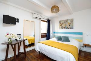 una camera da letto con un letto, un tavolo e uno specchio di B&B La Corte San Francesco a Bari