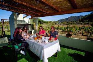 a group of people sitting at a table eating food at Casa Museddu in Cardedu