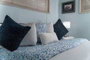 a bed with blue and white pillows on it at Walnut Bungalow West in Hillsboro
