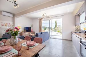 a kitchen and living room with a table and chairs at Nightingale Villa & Suites Corfu in Gazátika