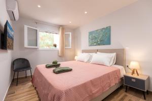 a bedroom with a bed with a pink blanket and a chair at Nightingale Villa & Suites Corfu in Gazátika +104 photos