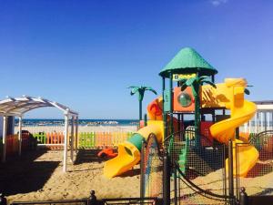 un parque infantil en la playa con una estructura de juegos en Hotel Derby en Cattolica