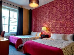ein Hotelzimmer mit 2 Betten und einer roten Wand in der Unterkunft Hotel Mondial in Tours