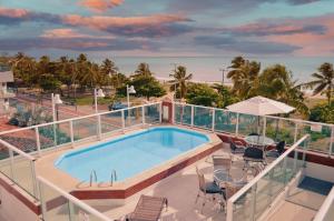 a balcony with a swimming pool and the beach at Nord Easy Ondas do Atlantico in João Pessoa