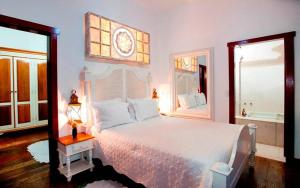 a bedroom with a large white bed and a window at Pousada Araujo Bazilio in Tiradentes